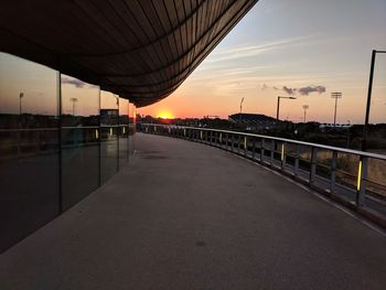 Bridge over road against sky during sunset