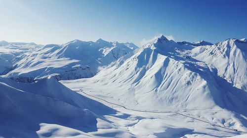 Scenic view of snowcapped mountains against blue sky