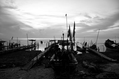 Boats moored at harbor against sky