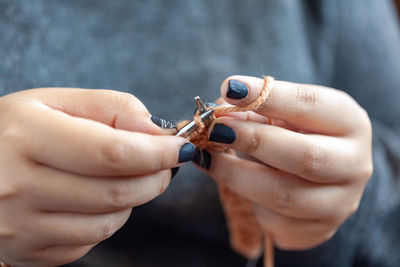 Close-up of hand holding cigarette against blurred background