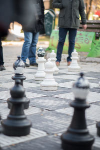 Low section of man walking on chess board