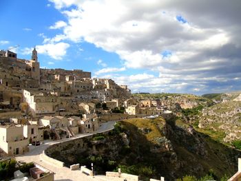 Houses on mountain against cloudy sky