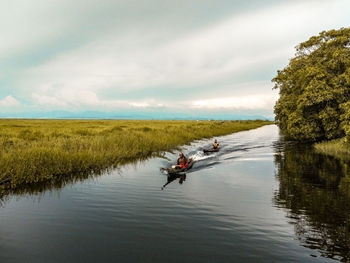 Man in boat on lake against sky