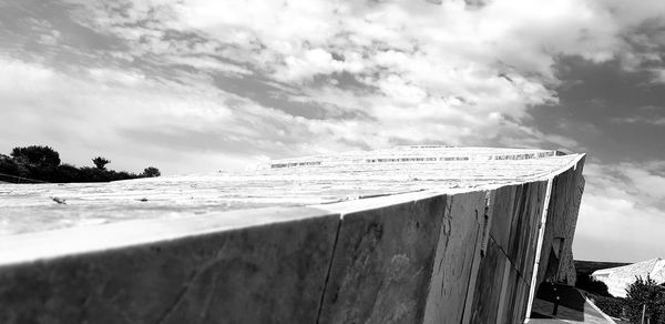 Wooden posts on beach against sky