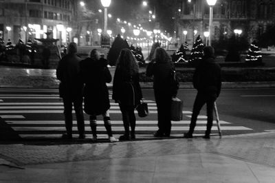 People in illuminated city at night