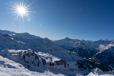 Scenic view of snowcapped mountains against clear sky