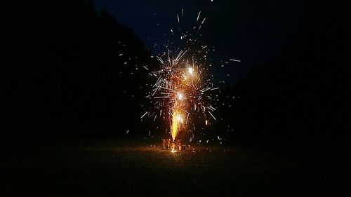 Firecracker burning on field at night