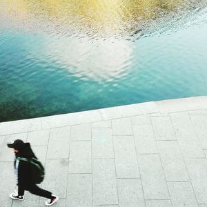 High angle view of woman walking by swimming pool