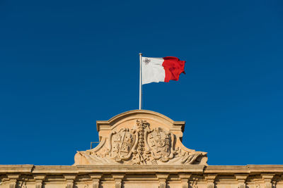 Low angle view of flag against blue sky