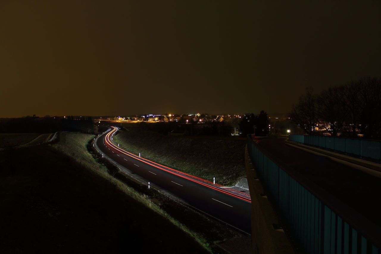 HIGH ANGLE VIEW OF LIGHT TRAILS ON ROAD IN CITY