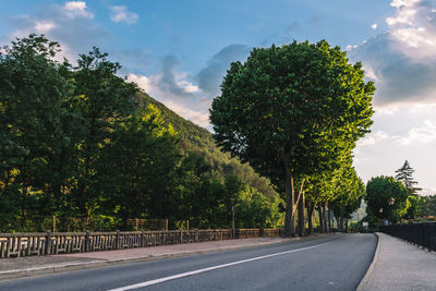 Road amidst trees against sky