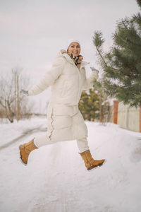 Portrait of smiling woman standing on snow