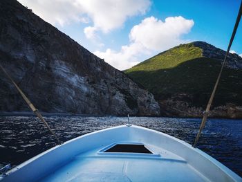 Scenic view of sea by mountains against sky