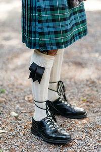 Low section of scottish groom standing on field 