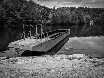 Abandoned boat moored on lake