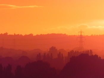 Scenic view of silhouette trees against orange sky