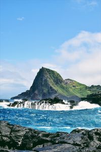 Scenic view of sea and mountains against sky