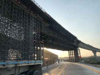 Bridge over road against sky in city