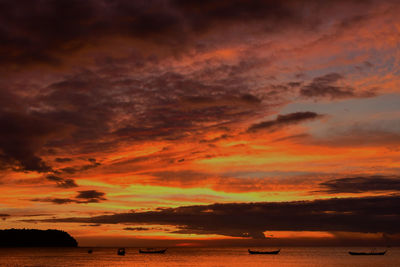 Scenic view of sea against dramatic sky during sunset