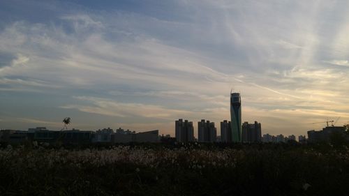 Buildings in city against cloudy sky