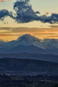 Scenic view of snowcapped mountains against sky during sunset