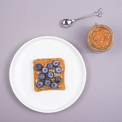 Sandwich with peanut butter blueberry and seeds on a gray background. 