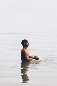 Side view of man swimming in lake