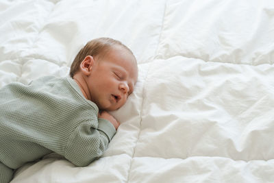 High angle view of baby sleeping on bed at home