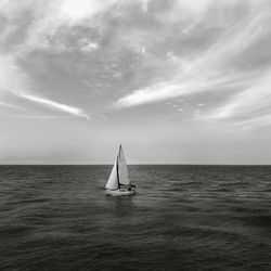 Sailboat sailing on sea against sky