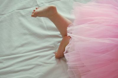 Low section of baby girl lying on bed
