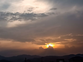 Low angle view of silhouette mountain against dramatic sky