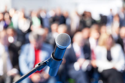 Close-up of microphone against crowd during event