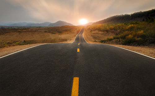 Road amidst landscape against sky during sunset