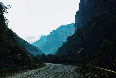 Road amidst mountains against clear sky