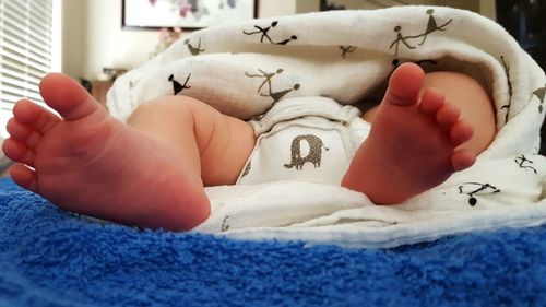 Close-up of hands holding heart shape on bed