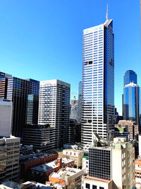 Modern buildings in city against blue sky