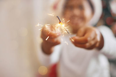 Midsection of woman holding sparkler