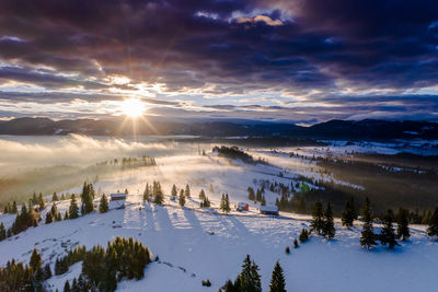 Scenic view of snow covered landscape against sky during sunset