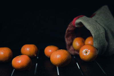 Close-up of oranges on table against black background