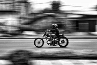 Rear view of man riding bicycle on street