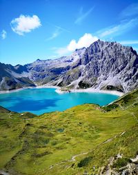 Scenic view of lake by mountains against sky