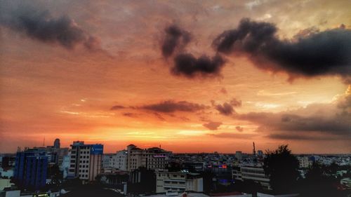 Silhouette cityscape against sky during sunset