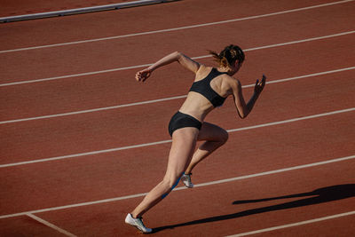 Female athlete beginning running 400 meters at stadium