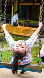 Close-up of girl on swing at playground