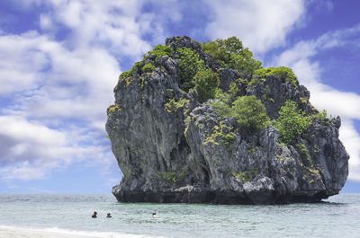 Rock formation by sea against sky