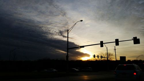 Illuminated street light against sky during sunset