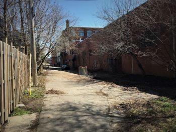 Empty road amidst buildings against sky