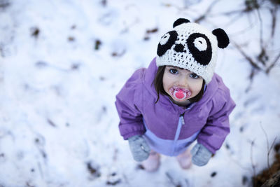 An overhead portrait of a little girl in the snow.