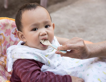 Cropped hand of grandmother feeding grandson