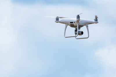 Low angle view of drone flying against sky